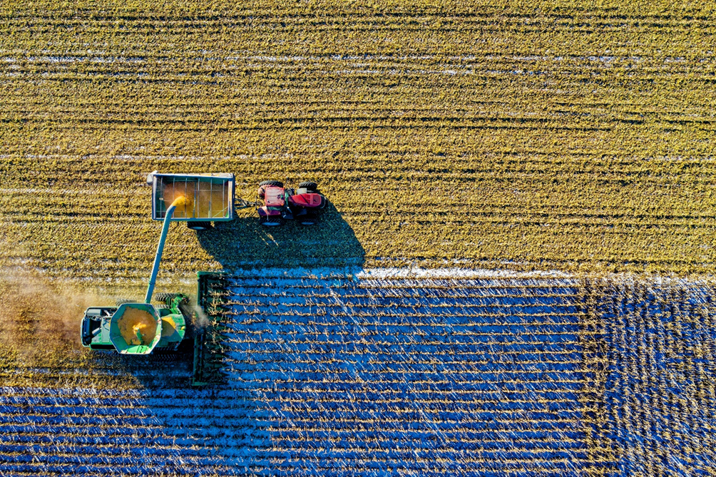 Foto scattata da drone con mietitrebbia che raccoglie cereali durante l'inverno